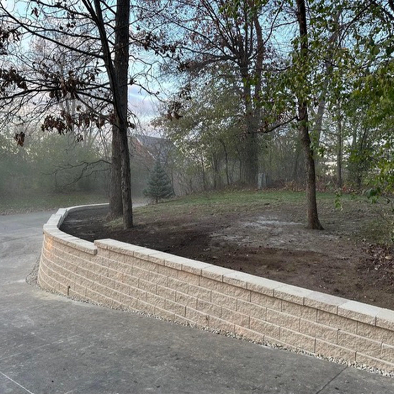 An image showcasing an impressive and sturdy curved roadside retention wall that was created out of white brick.