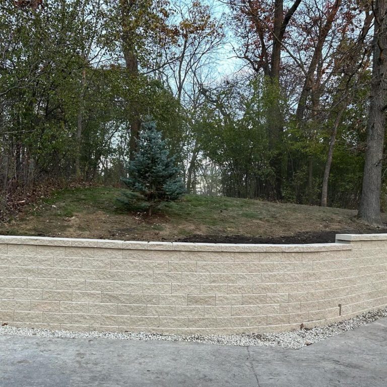 The after image showcasing an impressive and sturdy curved roadside retention wall that was created out of white brick.