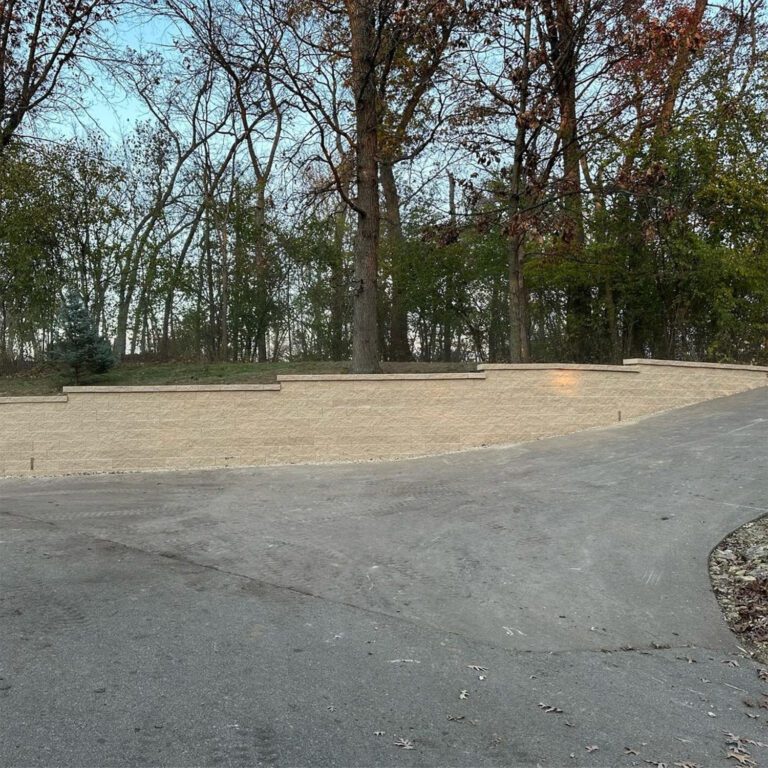 The after image showcasing an impressive and sturdy curved roadside retention wall that was created out of white brick.