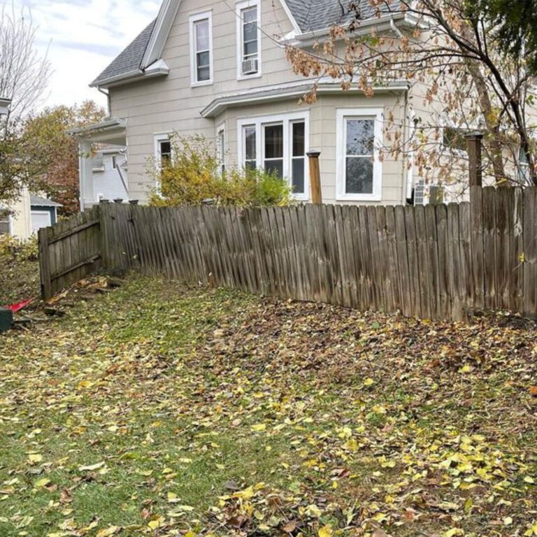 The after of a yard clearing project showing the overgrowth has been removed and the now unobstructed fence.