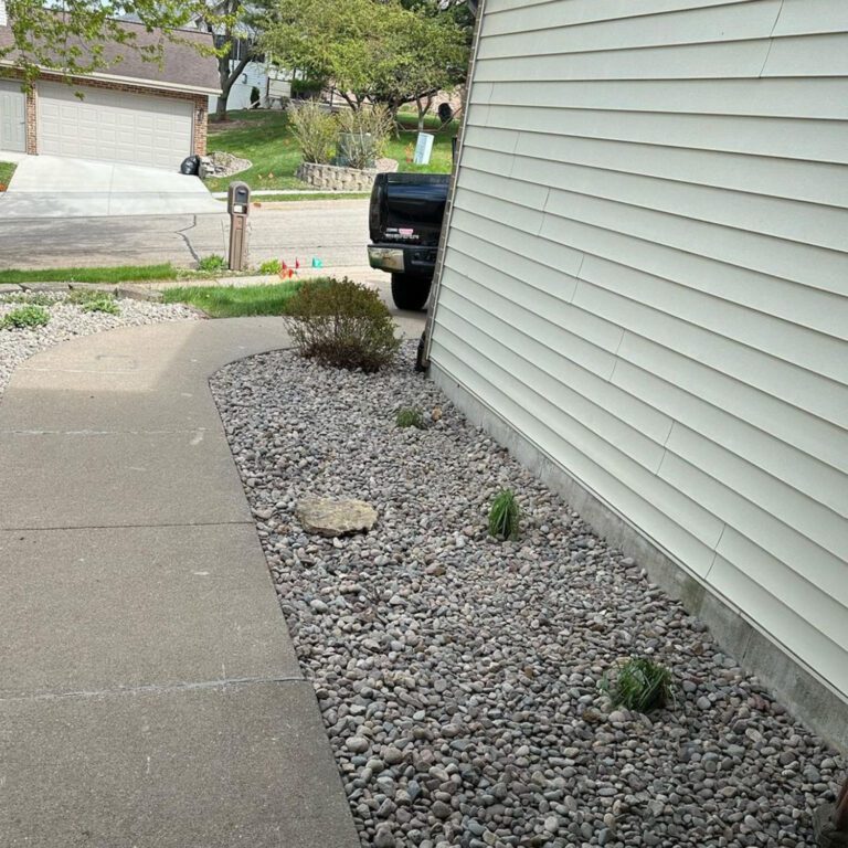 The after image of a tree removal project showing a clean area with landscaped rock replacing the tree.